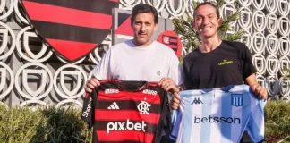 Filipe Luís e Diego Milito posam com camisas de Flamengo e Racing no Ninho do Urubu