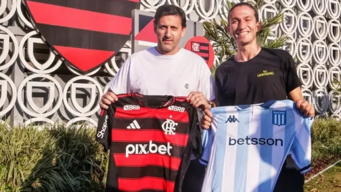 Filipe Luís e Diego Milito posam com camisas de Flamengo e Racing no Ninho do Urubu