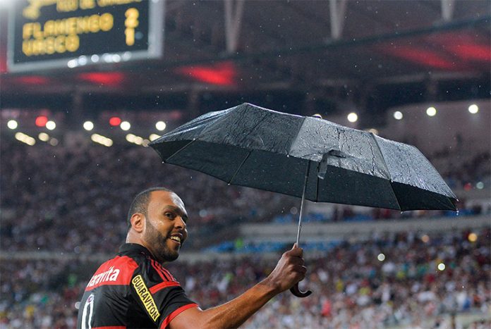 Alecsandro com guada-chuva em temporal no Maracanã