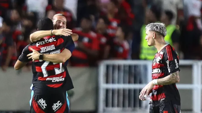 Observado pelo lateral direito Varela, Filipe Luís abraça o atacante Joshua