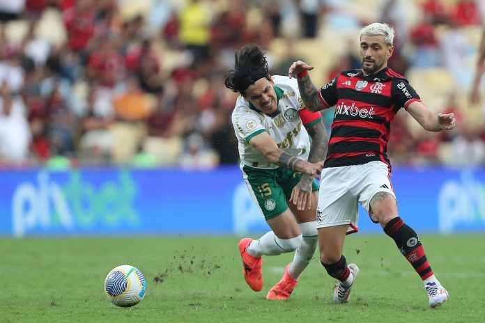 Arrascaeta disputa a jogada com Gustavo Gómez no jogo entre Flamengo e Palmeiras no Maracanã em 2024
