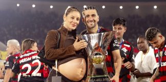 Arrascaeta e sua esposa Camila, grávida do primeiro filho do casal, com a taça de Campeão Brasileiro 2025 - Foto: Adriano Fontes / Flamengo