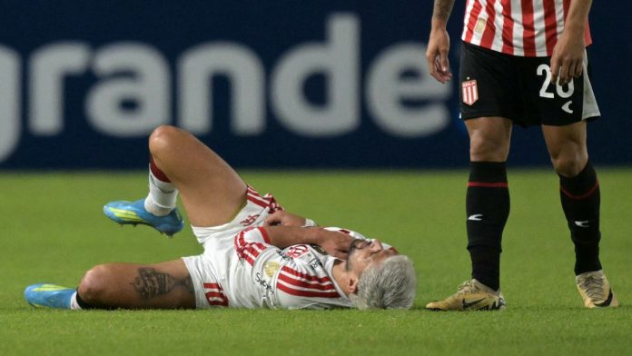 Arrascaeta caído logo após se machucar no jogo contra Estudiantes