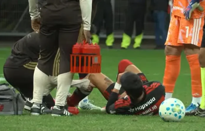 Luiz Araújo caído em campo após forte entrada durante vitória do Flamengo sobre o Olímpia em Brasília