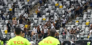 O árbitro Raphael Claus observa o tumulto promovido pela torcida do Atlético-MG