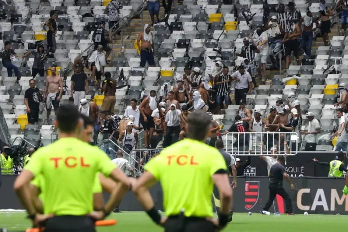 O árbitro Raphael Claus observa o tumulto promovido pela torcida do Atlético-MG