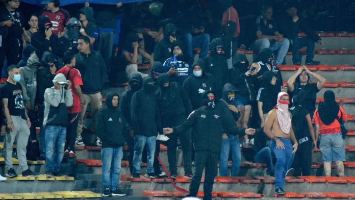 Torcedores encapuzados protestam nas arquibancadas do estádio Atanásio Girardot durante Independiente Medellín x Flamengo - Foto: Daniel Gallo / Vizzor Image / Getty Images