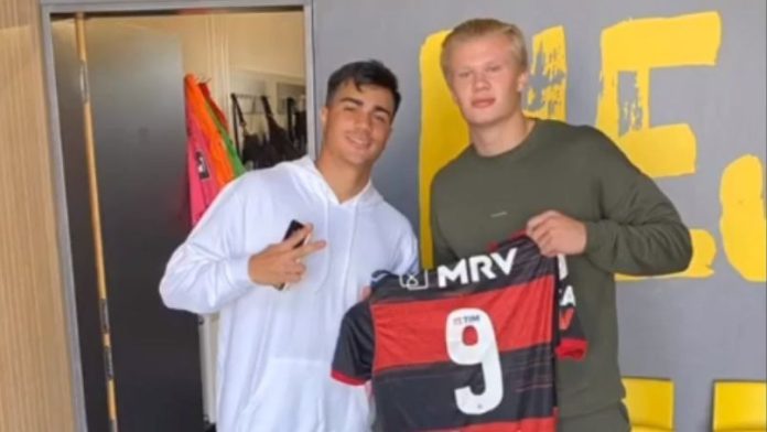 Haaland posa com o manto sangrado em mãos dado por Reinier, com ele na foto